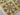 Holly - A floral-patterned rug with green and red flowers on a mustard background.