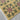 Holly - A floral-patterned rug with green and red flowers on a mustard background.